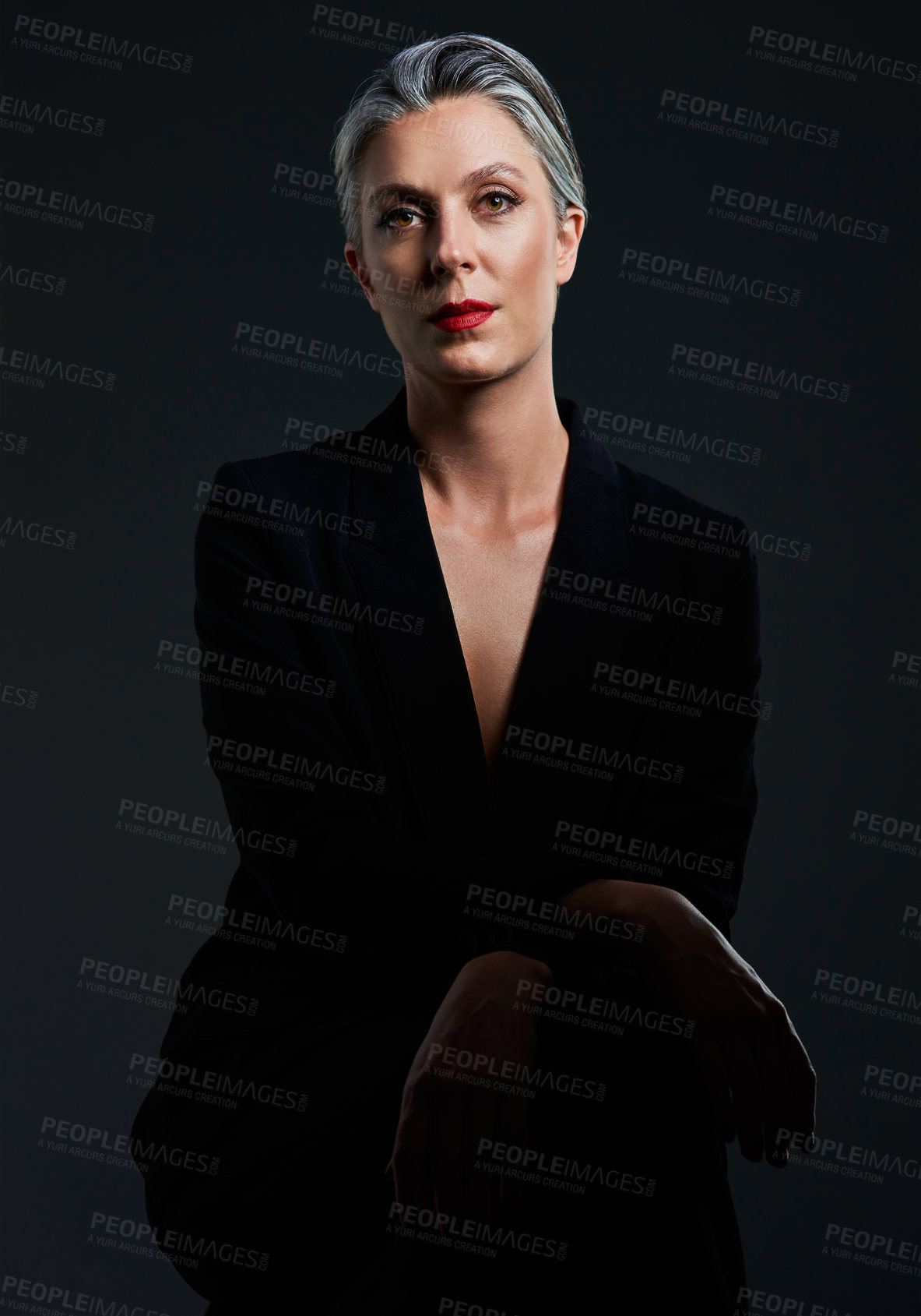 Buy stock photo Studio portrait of a beautiful mature woman posing against a dark background