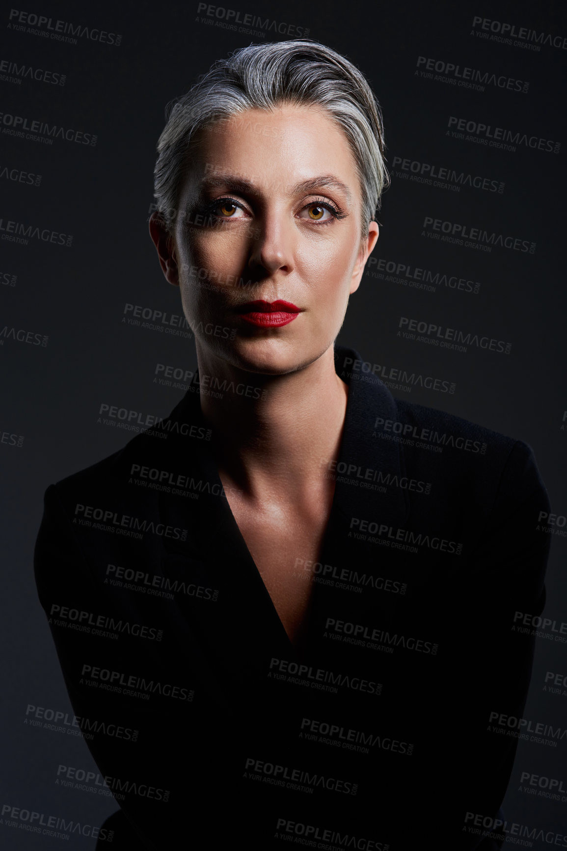 Buy stock photo Studio portrait of a beautiful mature woman posing against a dark background