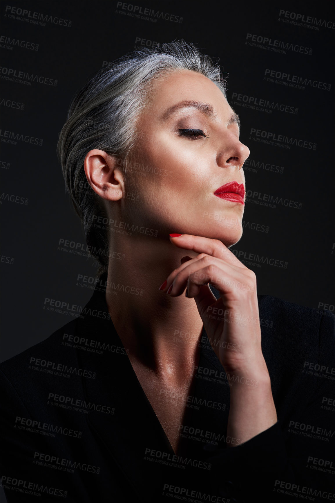 Buy stock photo Studio shot of a beautiful mature woman posing against a dark background