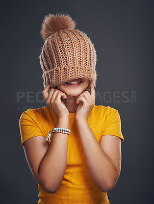 Buy stock photo Cropped shot of an unrecognizable teenage girl wearing a beanie and feeling playful against a dark studio background