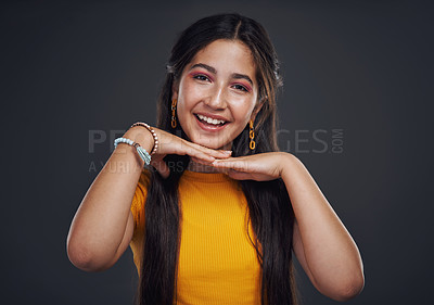 Buy stock photo Cropped portrait of an attractive teenage girl standing alone against a dark studio background with her hands to her face