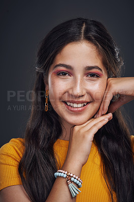 Buy stock photo Cropped portrait of an attractive teenage girl standing alone against a dark studio background with her hands to her face