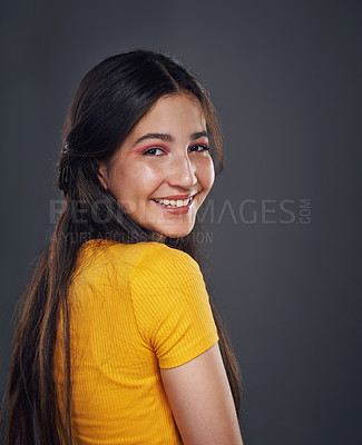 Buy stock photo Cropped portrait of an attractive teenage girl standing alone against a dark background in the studio