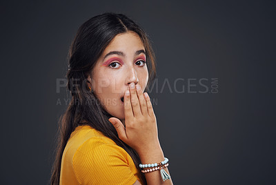 Buy stock photo Cropped portrait of an attractive teenage girl standing alone and looking surprised against a dark background in the studio