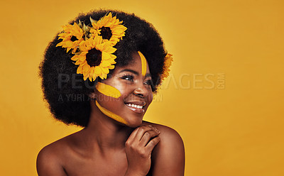 Buy stock photo Black person, plant and sunflower with skincare in studio for organic glow, cosmetics or soft skin. Woman, floral and mockup with thinking for natural, dermatology and vitamin e on yellow background