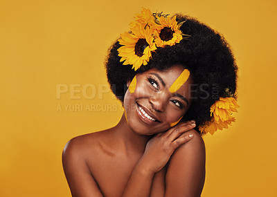 Buy stock photo Studio shot of a beautiful young woman smiling while posing with sunflowers in her hair against a mustard background