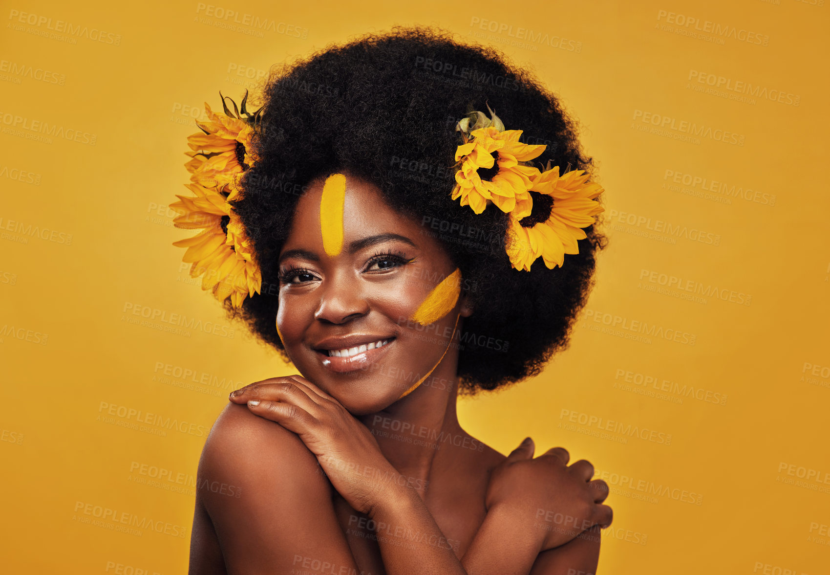 Buy stock photo Black woman, sunflowers in hair and make up on face in studio portrait for cosmetics, afro care and empowerment. Happy, lady and yellow paint on forehead for summer, spring or warmer weather 
