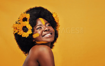 Buy stock photo Beautiful black woman, sunflowers in hair and make up on face in studio for cosmetics, afro care and empowerment. Happy, lady and mustard paint on forehead for summer, spring or warmer weather 