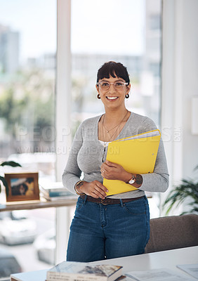 Buy stock photo Cropped portrait of an attractive young businesswoman standing alone and holding files in her office