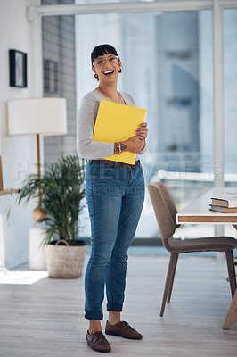 Buy stock photo Full length portrait of an attractive young businesswoman standing alone and holding files in her office