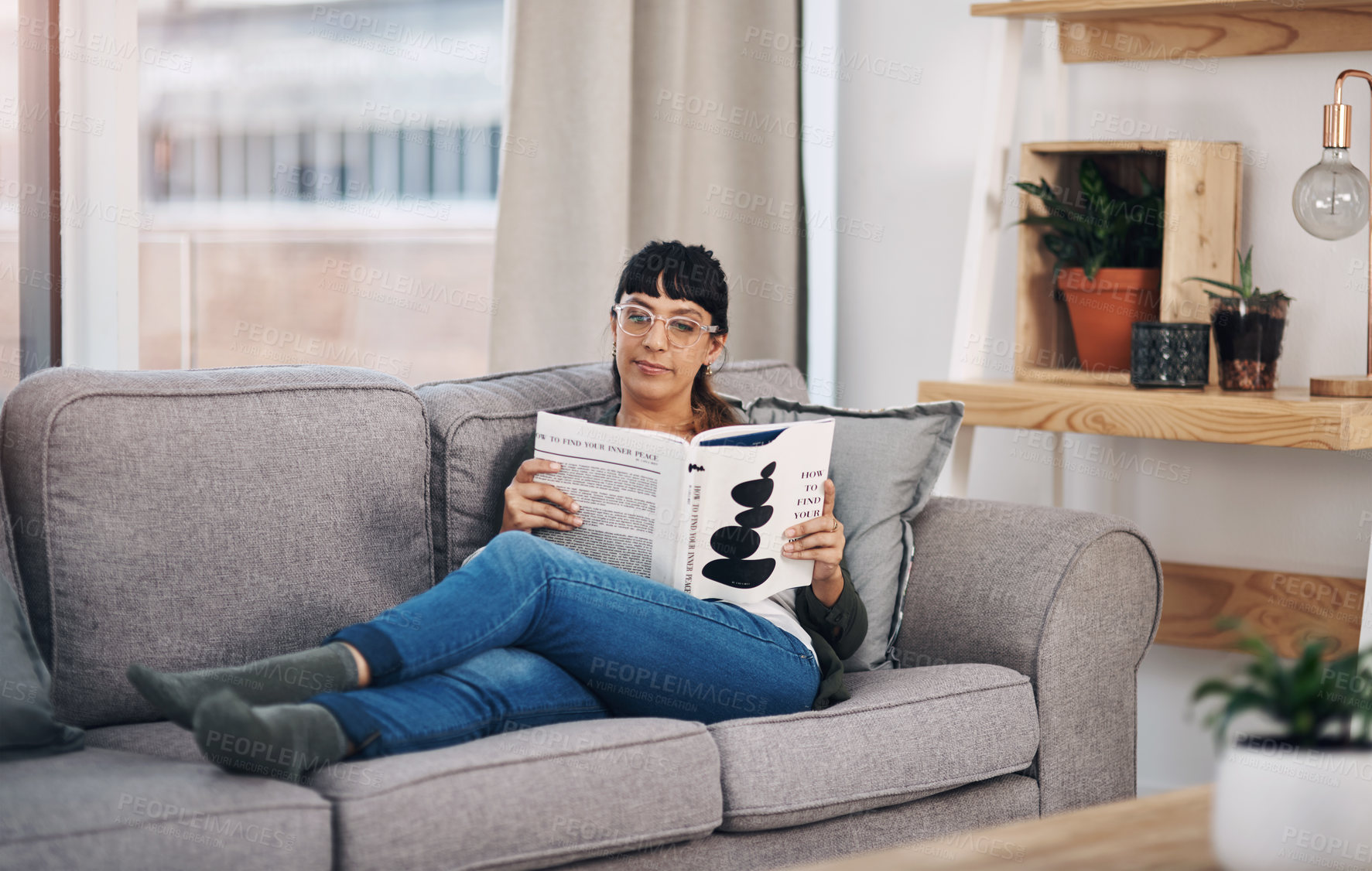 Buy stock photo Relaxing, reading and woman with book on sofa in home for calm, peace and self help literature. Weekend, rest and person in living room with non fiction story for psychology knowledge in apartment.