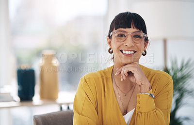 Buy stock photo Cropped portrait of an attractive young businesswoman sitting alone in her office with her hand on her chin