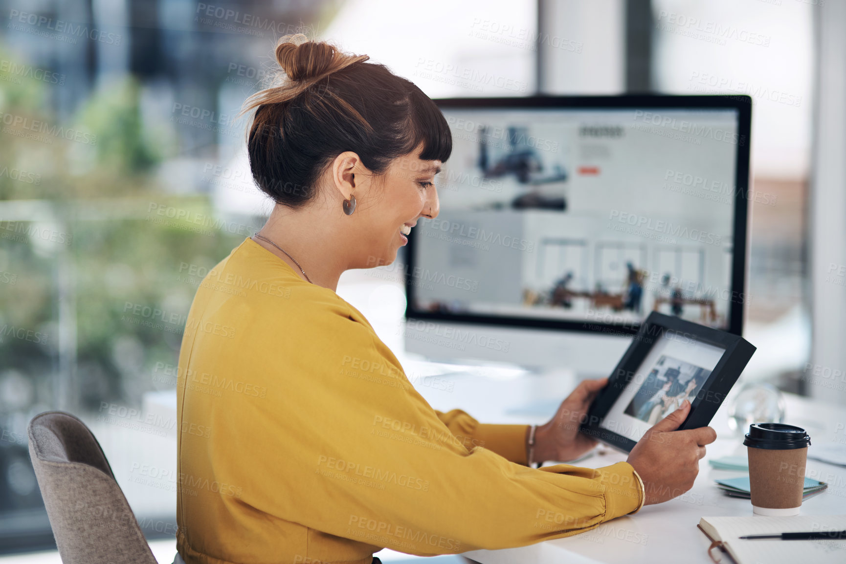 Buy stock photo Office, smile and woman with photo frame at desk for connection, comfort and happy memory at work. Creative, female person and tech with picture in morning for inspiration, nostalgia and reflection