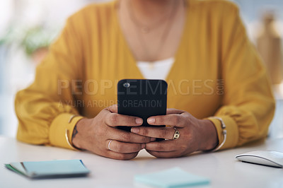 Buy stock photo Cropped shot of an unrecognizable businesswoman sitting alone in her office and using her cellphone
