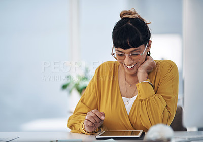 Buy stock photo Cropped shot of an attractive young businesswoman sitting alone in her office and using a tablet