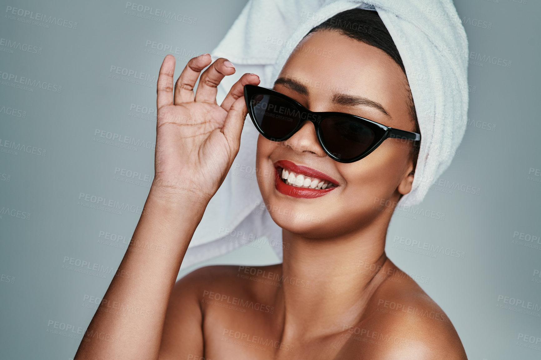 Buy stock photo Sunglasses, towel and woman with lipstick in studio for beauty, makeup and self care. Smile, portrait and female model with facial accessory and cosmetic for wellness, spa and glow by gray background