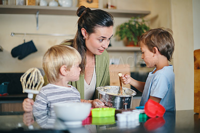 Buy stock photo Shot of a young woman baking with her two adorable sons at home