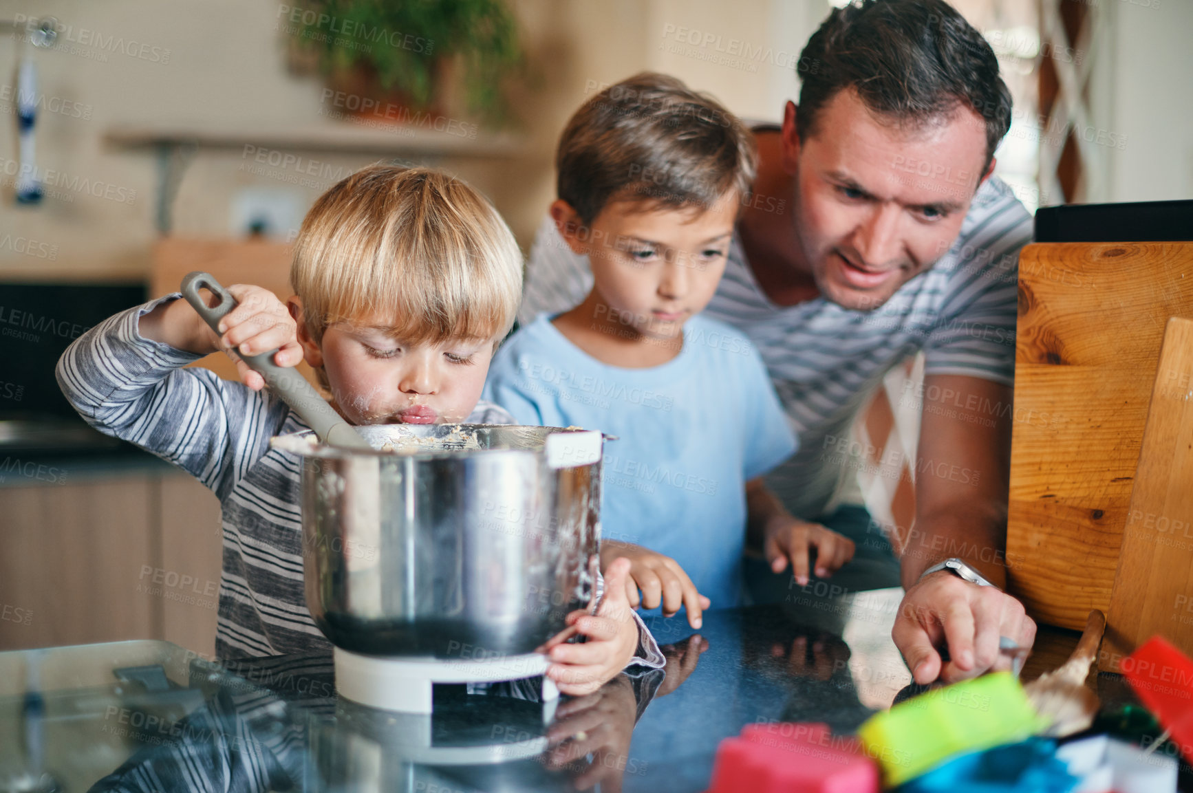 Buy stock photo Shot of a young man baking with his two adorable sons at home