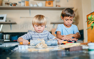 Buy stock photo Shot of two adorable little boys baking together at home