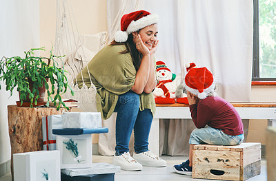Buy stock photo Shot of a young woman spending quality time with her adorable son at Christmas