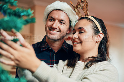 Buy stock photo Happy couple, christmas tree and hat with decor for festive holiday, december weekend or celebration together at home. Man and woman with smile and reindeer antlers for festivity or new year at house