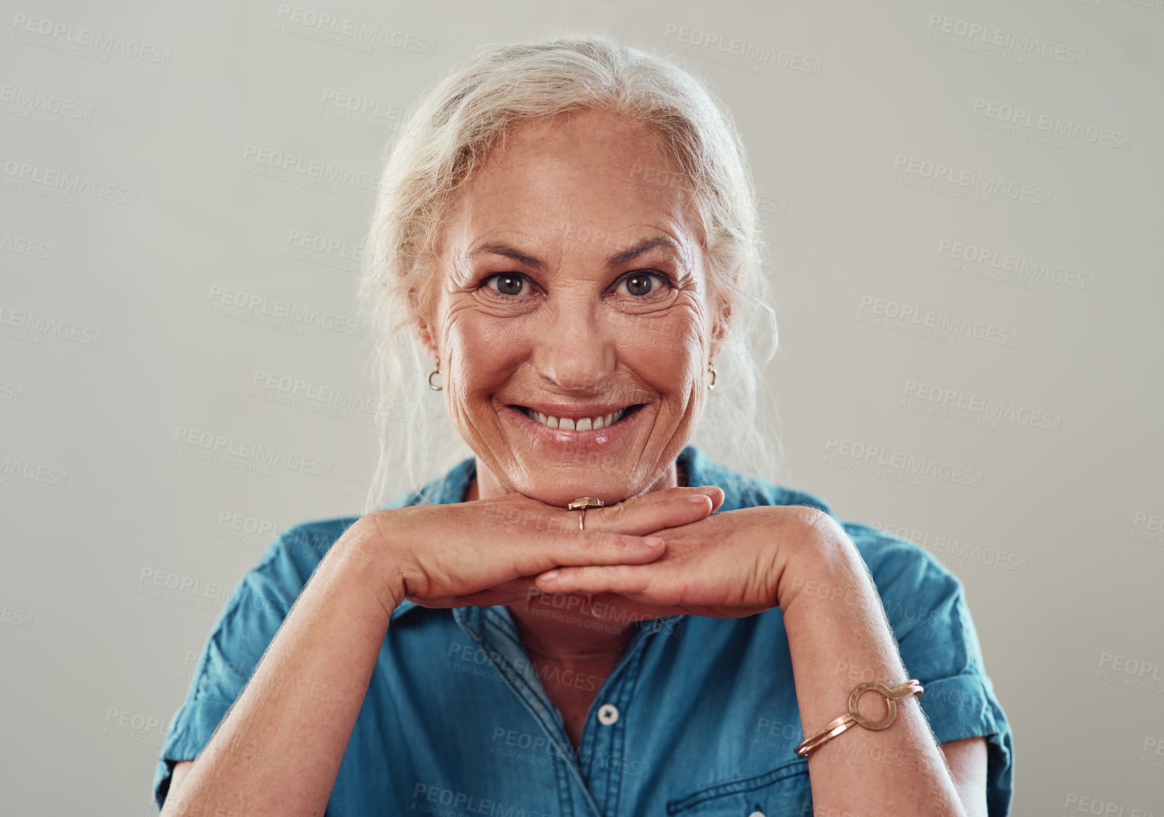 Buy stock photo Cropped portrait of an attractive senior woman posing against a grey background at home