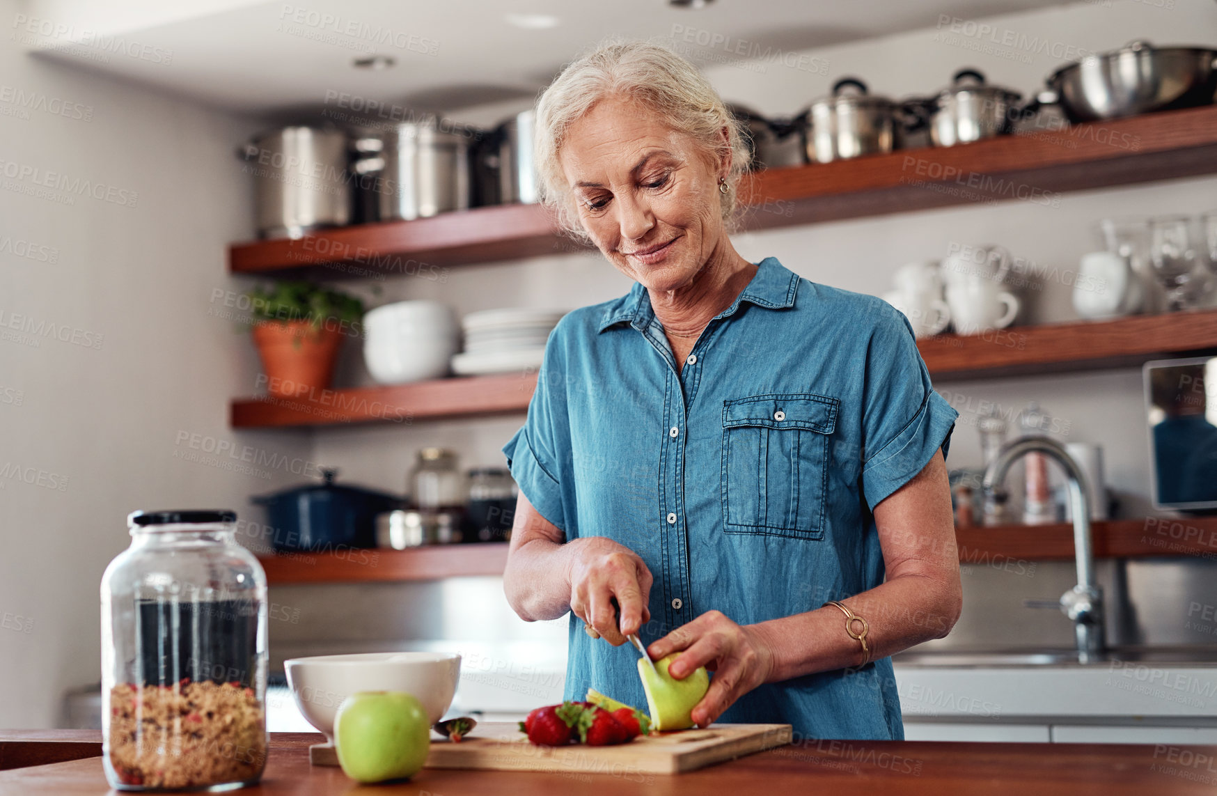 Buy stock photo Senior woman, cooking and home with cutting apple for breakfast or health, vegan diet or nutrition for wellness. Female person, kitchen and knife with fruit for relax or retirement, food or muesli