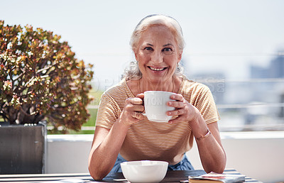 Buy stock photo Cropped portrait of an attractive senior woman enjoying her breakfast while sitting outside on the balcony at home
