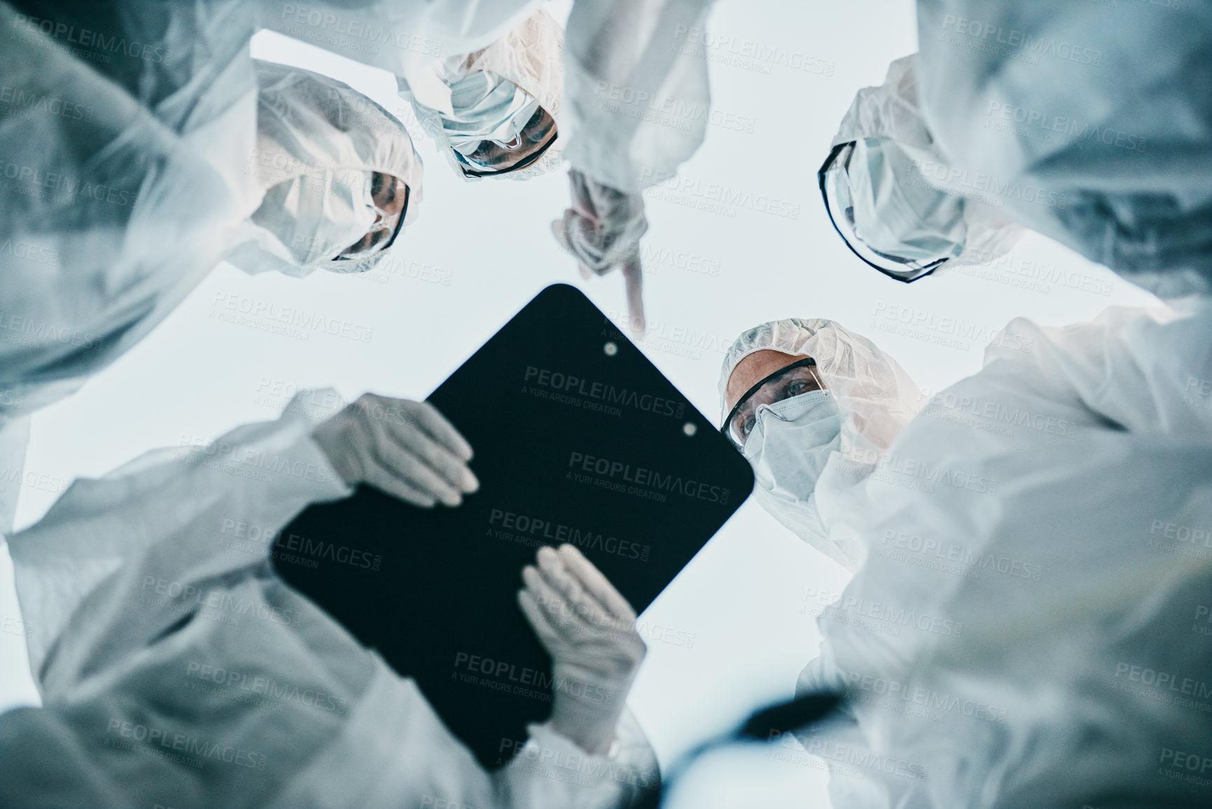 Buy stock photo Hazmat healthcare workers from below, working together during covid pandemic wearing face masks. Team of doctors wearing quarantine suits discussing medical lab results of the virus spread 