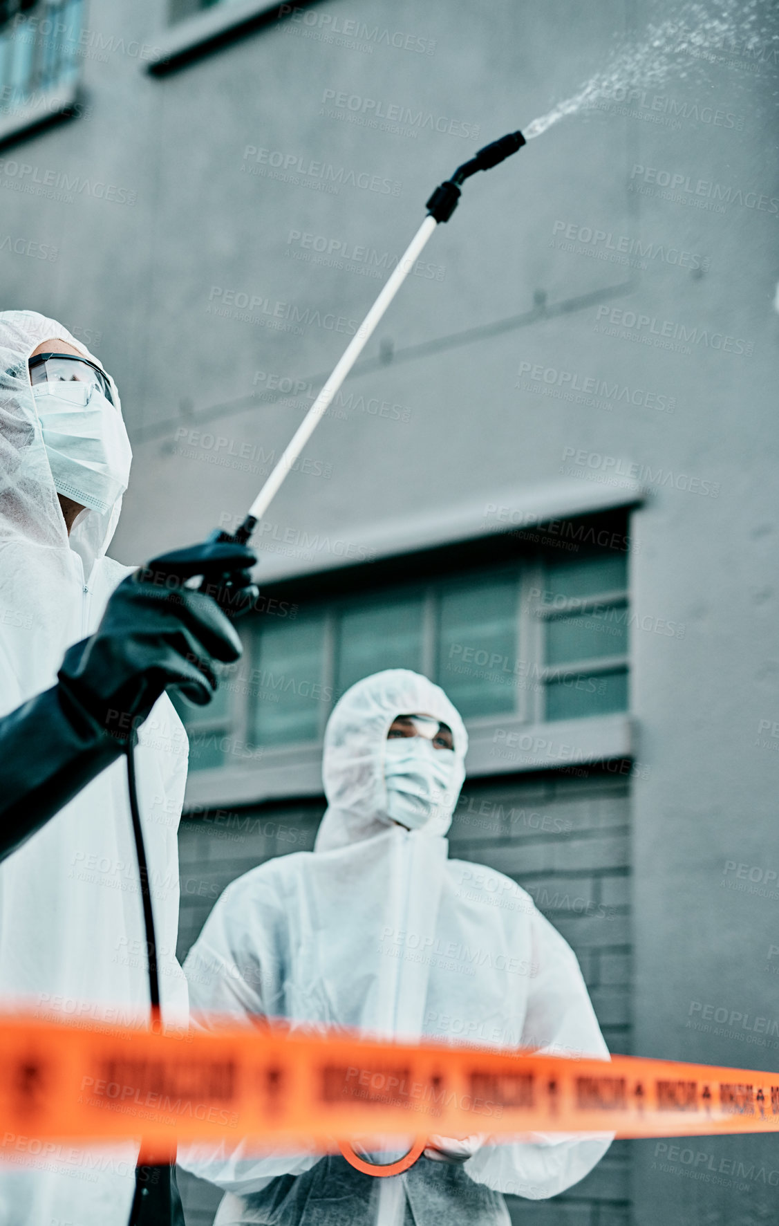 Buy stock photo Healthcare workers wearing hazmat suits disinfecting a building during covid pandemic. First responders spraying virus protection sanitizer or cleaning to prevent the spread of germs and for hygiene