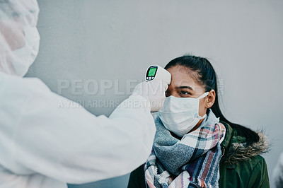 Buy stock photo Healthcare doctor scanning the temperature of a patient for corona with a digital, infrared thermometer. Medical professional in safety suit doing a coronavirus check on a woman during the outbreak.
