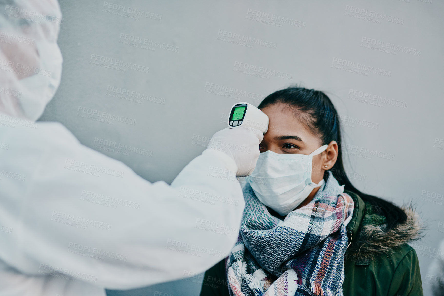 Buy stock photo Healthcare doctor scanning the temperature of a patient for corona with a digital, infrared thermometer. Medical professional in safety suit doing a coronavirus check on a woman during the outbreak.

