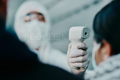 Buy stock photo Medical healthcare worker, scanning temperature of covid patient for safety against virus pandemic, wearing protective suit. Doctor in hazmat suit checking with thermometer for potential outbreak. 