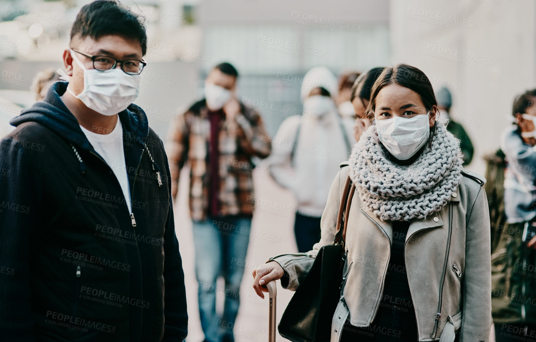 Buy stock photo Shot of a young man and woman wearing masks while travelling in a foreign city