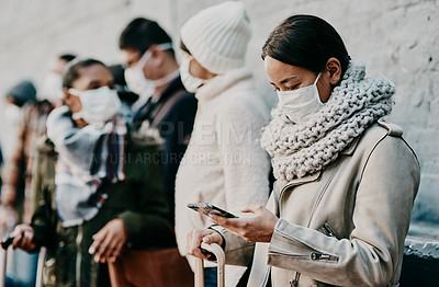 Buy stock photo People or tourists traveling during covid and standing in line at a public travel facility wearing protective masks. Woman in a queue reading social media news about coronavirus pandemic on her phone