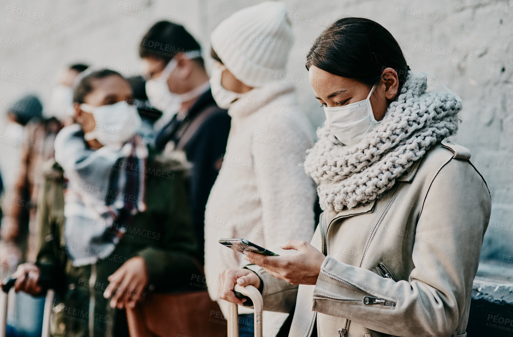 Buy stock photo People or tourists traveling during covid and standing in line at a public travel facility wearing protective masks. Woman in a queue reading social media news about coronavirus pandemic on her phone