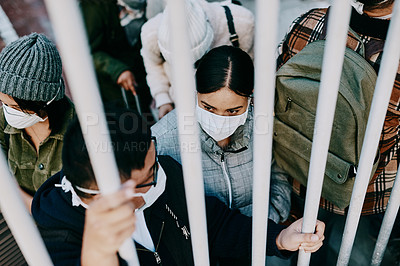 Buy stock photo Covid travel ban, lockdown or border control to prevent spread of pandemic virus, contagious disease or illness. Travelers in masks facing quarantine, abuse and discrimination behind locked gate 
