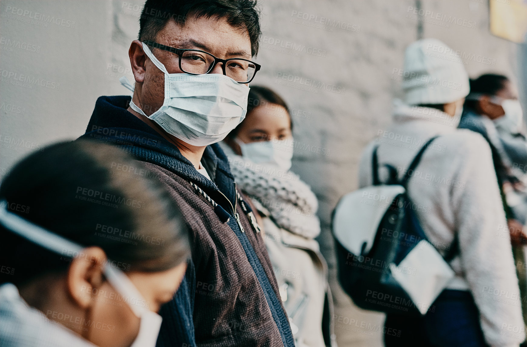 Buy stock photo Compliance, safety and covid travel restrictions with a group waiting in line to get a vaccine or booster shot. Corona face mask requirement in a crowd with diverse people waiting in to go abroad 