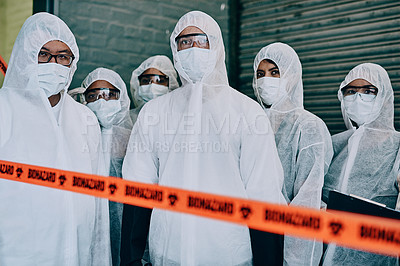 Buy stock photo Covid, pandemic and team doctors, scientists or heathcare workers wearing protective ppe to prevent virus spread at a quarantine site. First responders wearing hazmat suits while standing behind tape