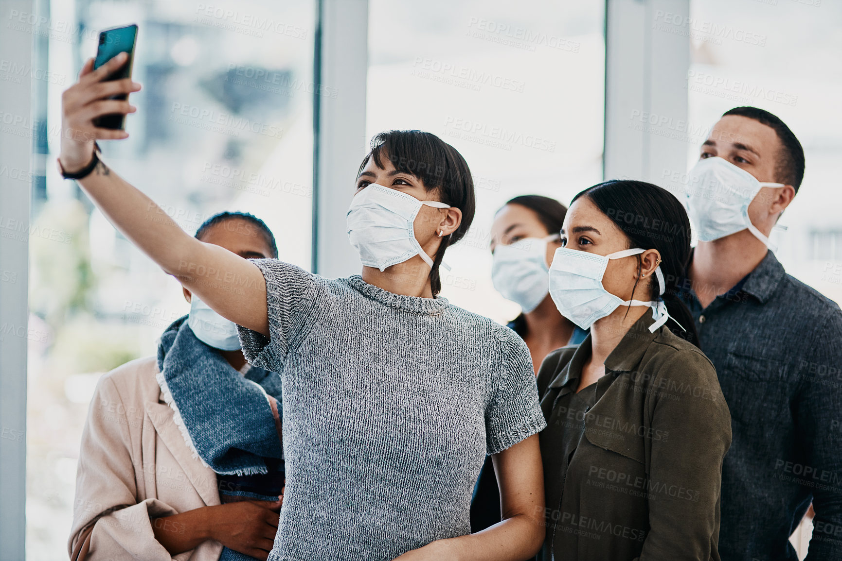 Buy stock photo Shot of a group of young people wearing masks and taking selfies at the airport