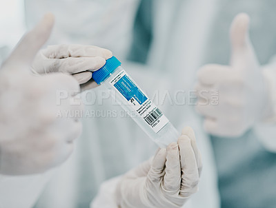 Buy stock photo Cropped shot of scientists holding a vial and showing thumbs up while conducting medical research in a laboratory
