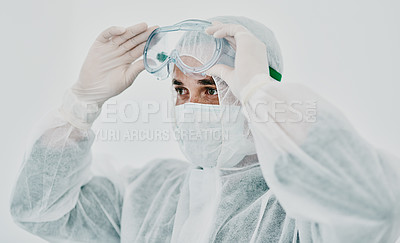 Buy stock photo Covid, healthcare worker with safety protection clothing during first virus outbreak. A medical research professional in a hazmat suit and goggles preparing for work and staying safe during pandemic