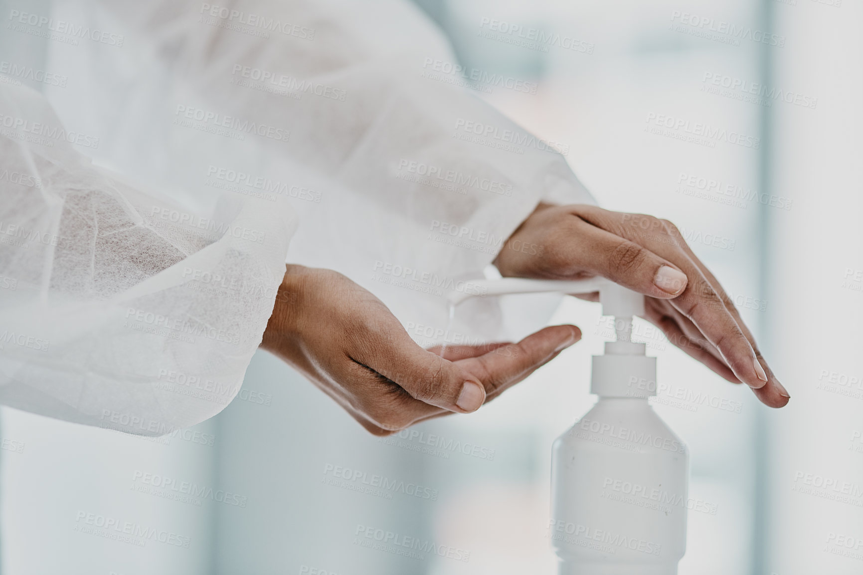 Buy stock photo Cropped shot of a healthcare worker disinfecting herself with hand sanitiser