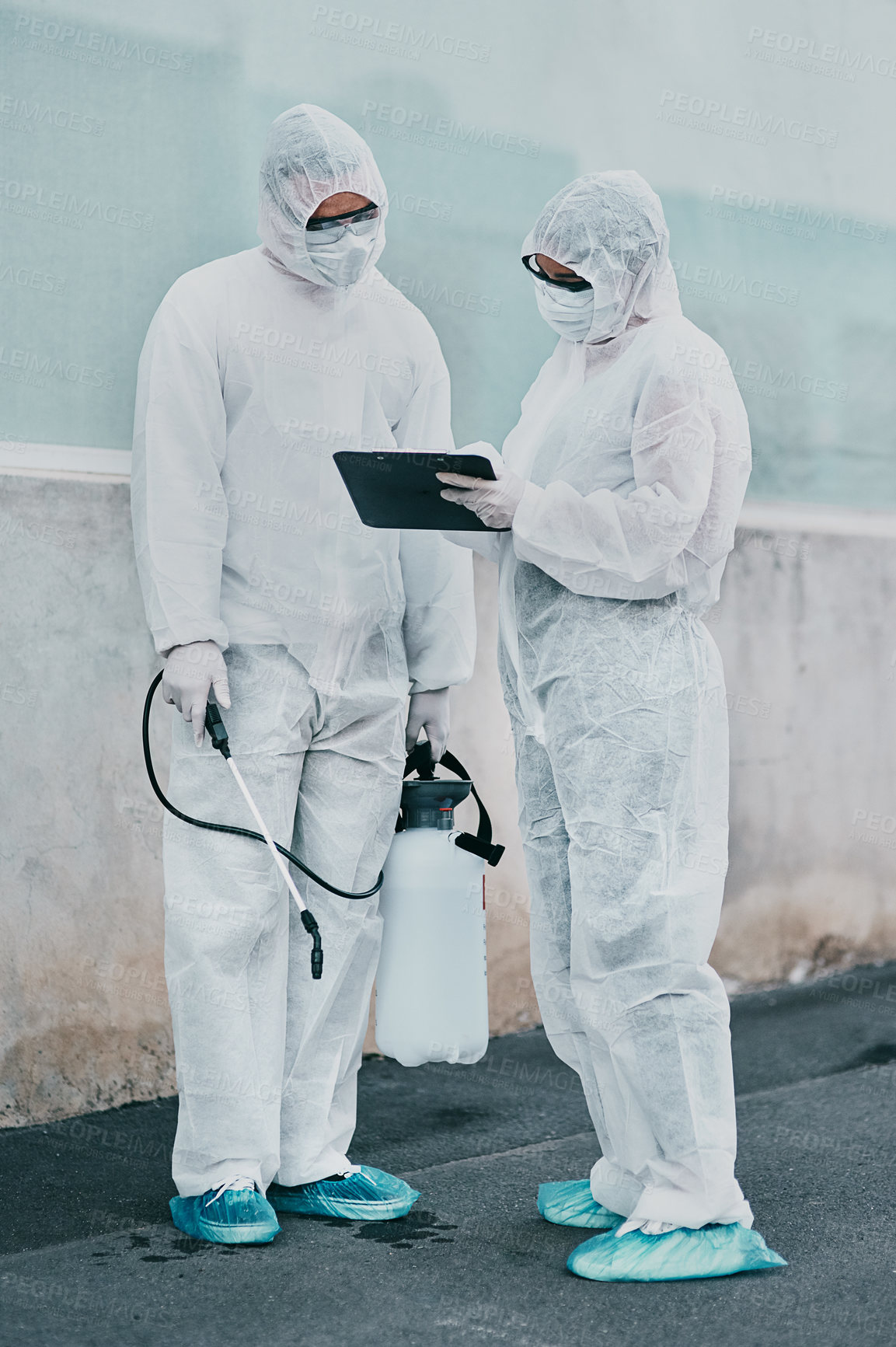 Buy stock photo Healthcare workers cleaning outside a building using a list to follow instructions on biohazard safety during covid. Medical researchers wearing hazmat suits sanitizing outdoor to prevent infections