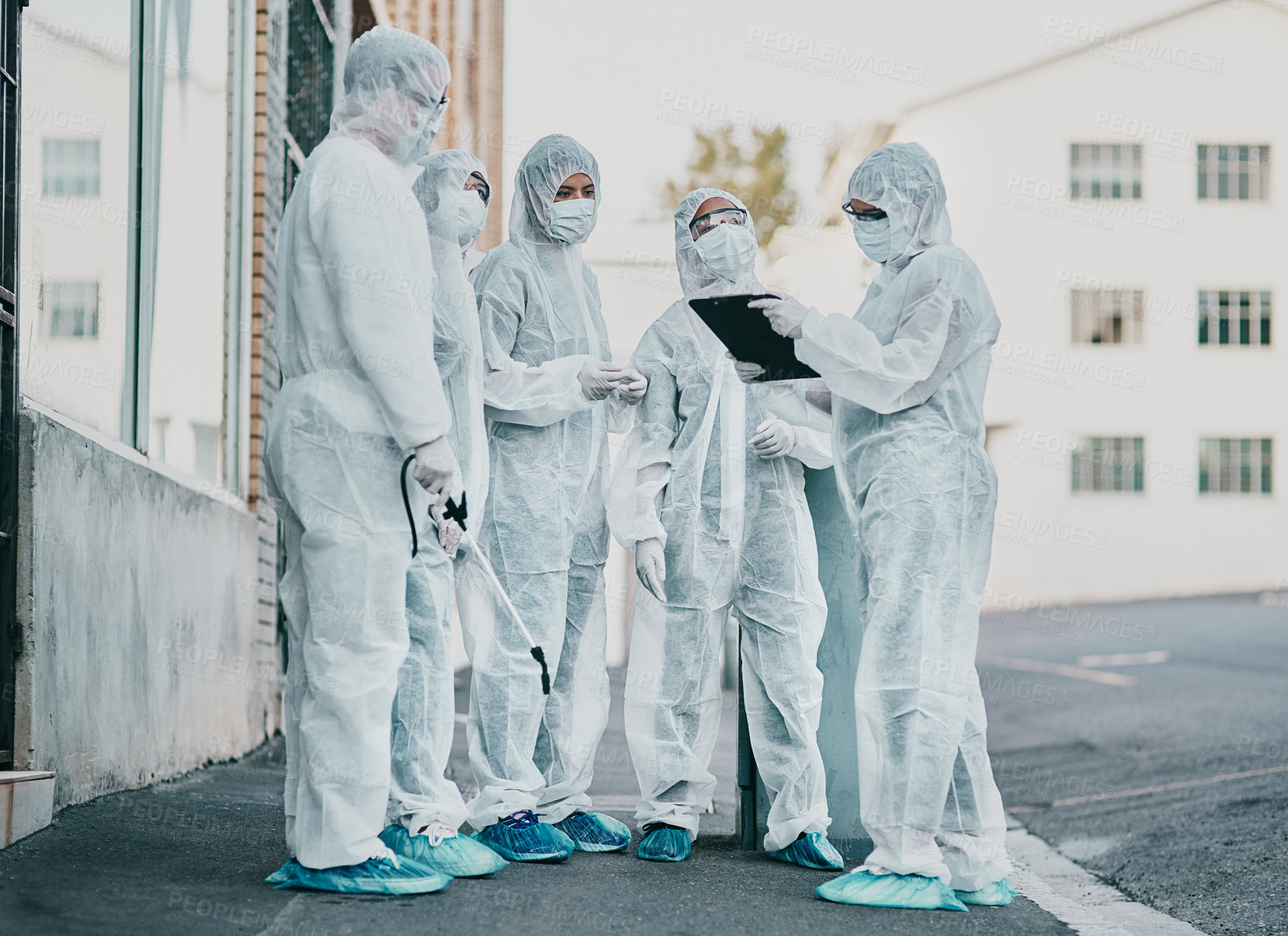 Buy stock photo Covid, pandemic and healthcare team wearing protective ppe to prevent virus spread at a quarantine site. First responders wearing hazmat suits while discussing plan for cleaning and disinfecting 