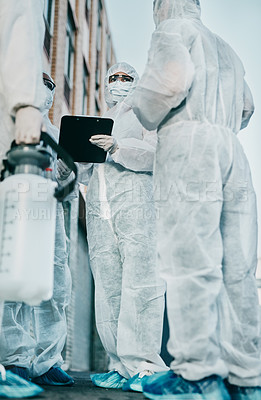Buy stock photo Healthcare workers outside in protective gear during an outbreak in the city. A group of scientists wearing hazmat suits, cleaning urban areas. Safety staff in coveralls due to covid health risks.