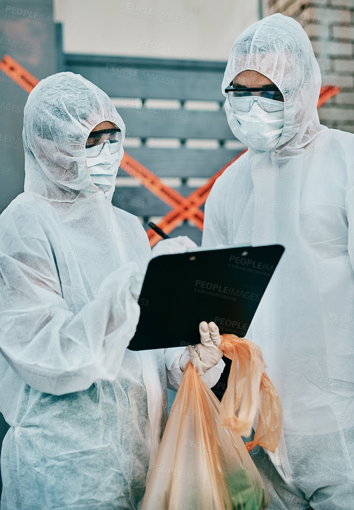 Buy stock photo Shot of two healthcare workers wearing hazmat suits working together to control an outbreak