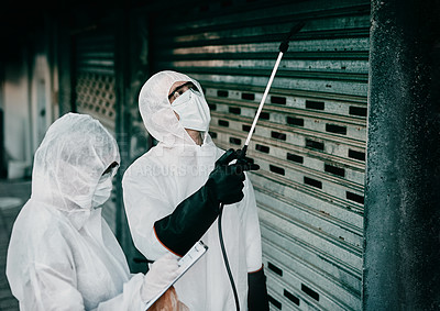 Buy stock photo Healthcare workers disinfecting a building during the covid pandemic or cleaning it to prevent the spread of infection. Specialists spraying sanitizer outdoors wearing protective hazmat suits