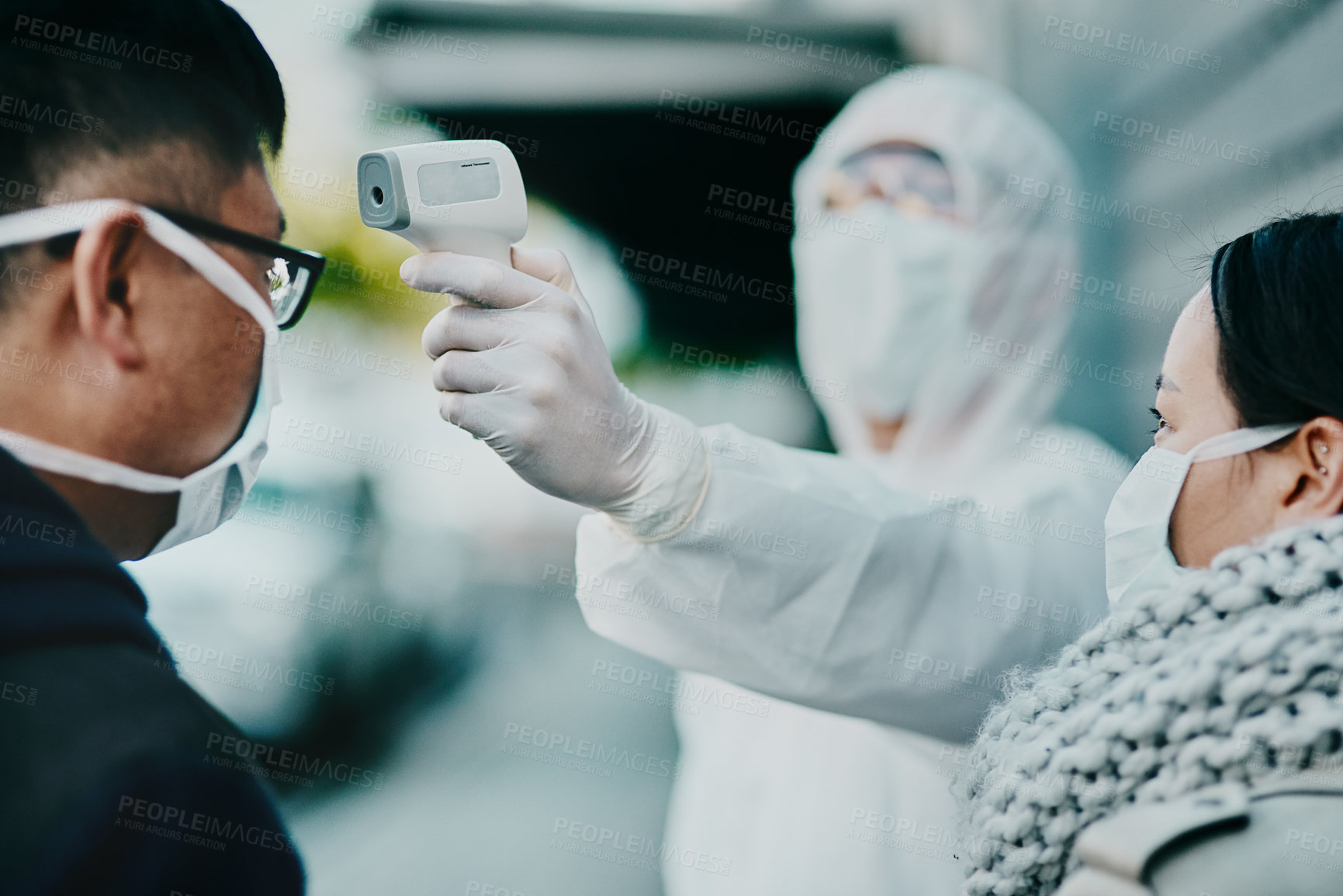 Buy stock photo Healthcare worker testing covid temperature for protocol, compliance or countries restrictions at an airport or border. Foreign traveling people with face mask in quarantine or corona virus screening