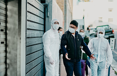 Buy stock photo Man breaking covid regulation getting taken away or arrested by healthcare workers wearing hazmat protective suits. Male removed for not following the rules or restrictions of coronavirus pandemic